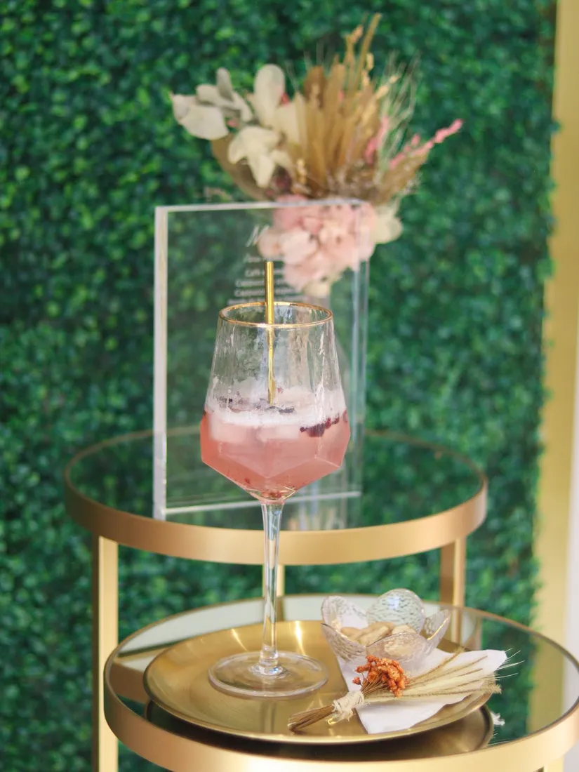 Taça com bebida e flores secas servida na recepção