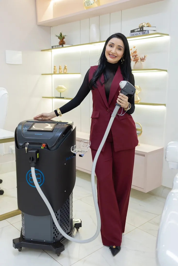Ludmilla Oliveira ao lado do equipamento de depilação a laser da clínica