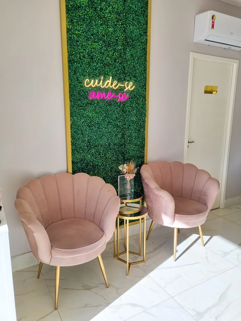 Sala de espera com poltronas rosadas e parede verde com o letreiro cuide-se, ame-se